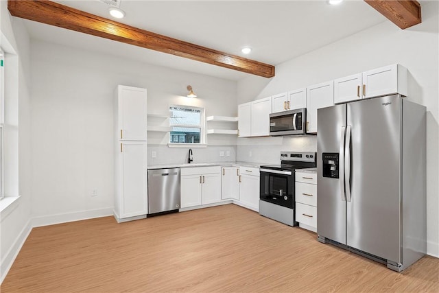 kitchen with beam ceiling, tasteful backsplash, white cabinets, and stainless steel appliances