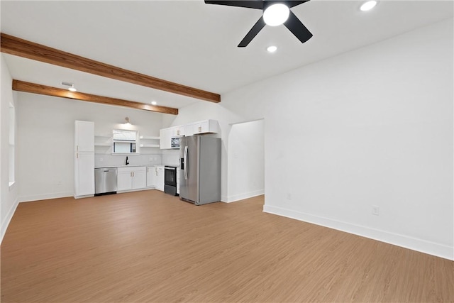 unfurnished living room featuring beamed ceiling, ceiling fan, light hardwood / wood-style floors, and sink