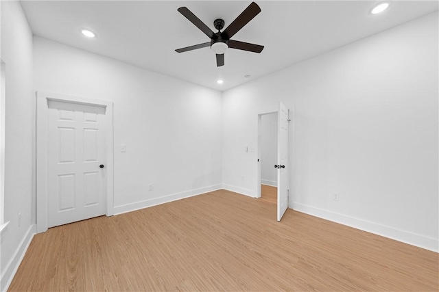 empty room with ceiling fan and light hardwood / wood-style floors