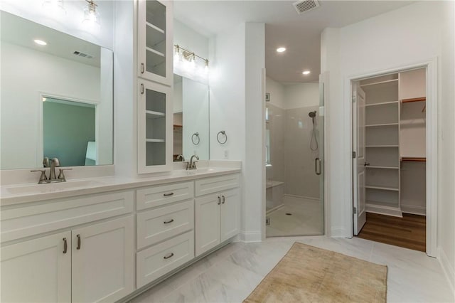 bathroom with vanity and a shower with door