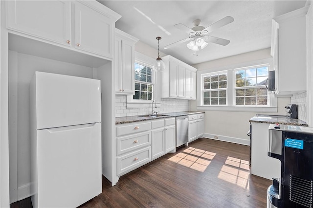 kitchen with sink, dark stone counters, decorative backsplash, white cabinets, and appliances with stainless steel finishes