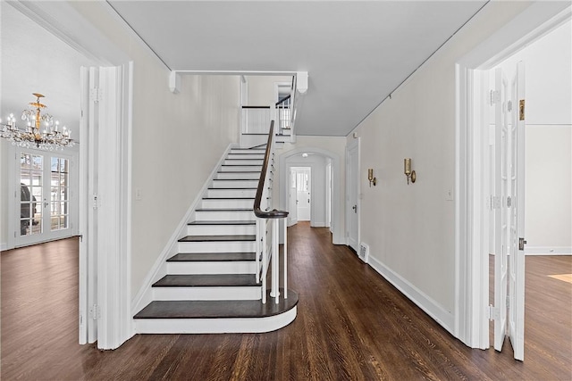 staircase featuring a notable chandelier and wood-type flooring