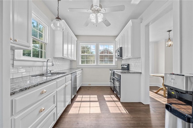 kitchen with white cabinets, dark hardwood / wood-style floors, stainless steel appliances, and hanging light fixtures