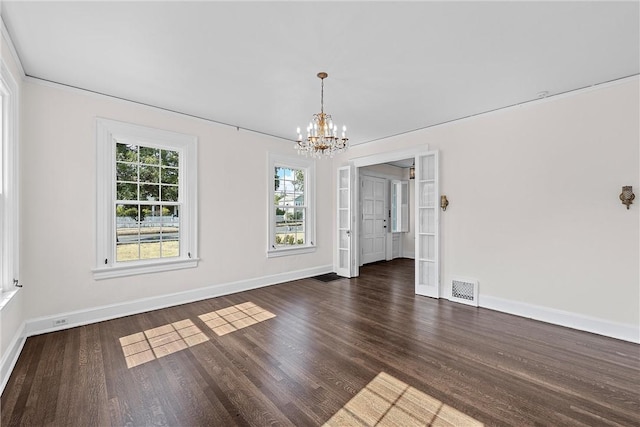 unfurnished dining area featuring dark hardwood / wood-style floors and an inviting chandelier