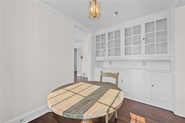 dining area featuring dark wood-type flooring and an inviting chandelier