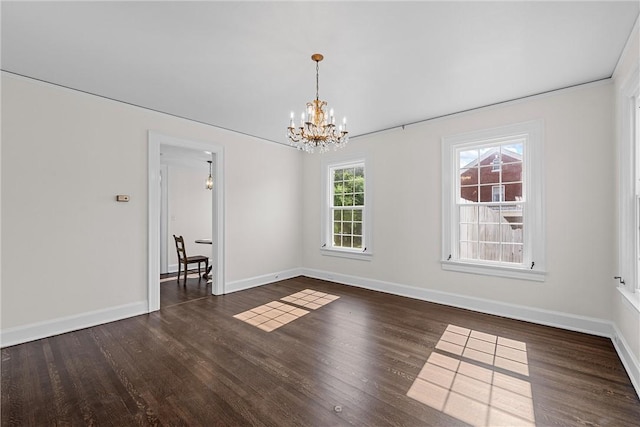 unfurnished room with dark wood-type flooring and a notable chandelier