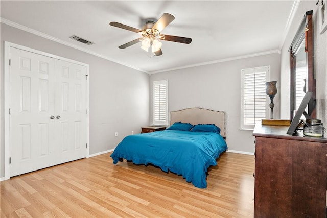 bedroom featuring a closet, ceiling fan, light hardwood / wood-style flooring, and ornamental molding