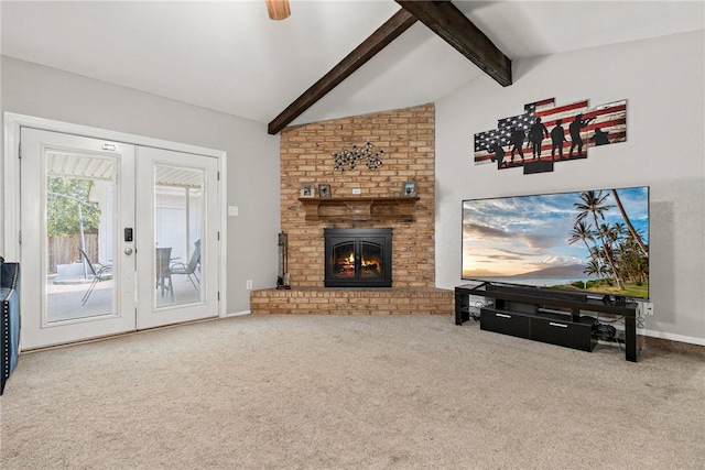 living room with carpet flooring, french doors, lofted ceiling with beams, and a brick fireplace