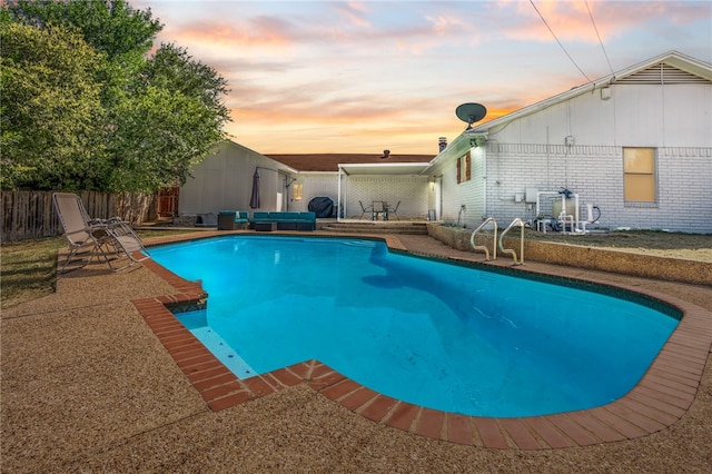 pool at dusk with a patio