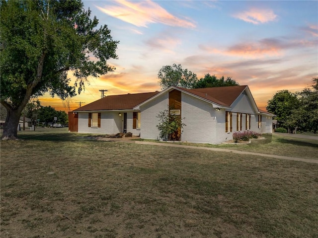 ranch-style home featuring a lawn