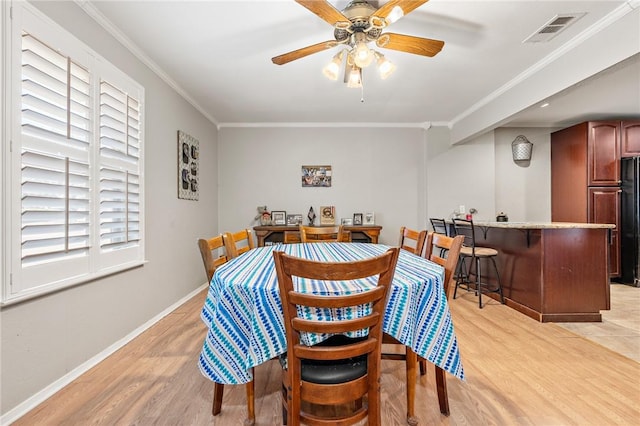 dining room featuring crown molding, ceiling fan, and light wood-type flooring