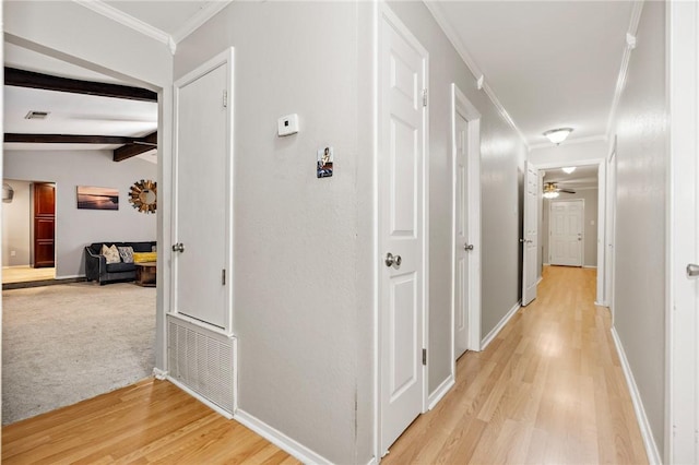 corridor with lofted ceiling with beams, light hardwood / wood-style floors, and ornamental molding