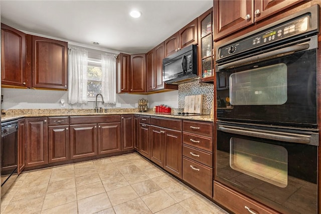 kitchen with black appliances, light stone countertops, sink, and light tile patterned floors