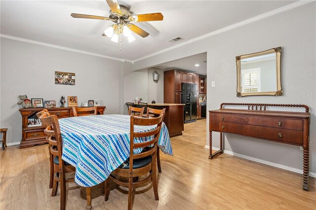 dining area with light hardwood / wood-style flooring, ceiling fan, and crown molding