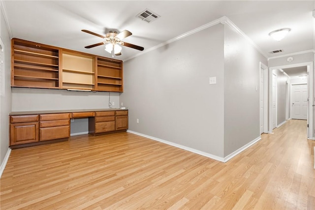 unfurnished office featuring built in desk, light hardwood / wood-style flooring, ceiling fan, and ornamental molding