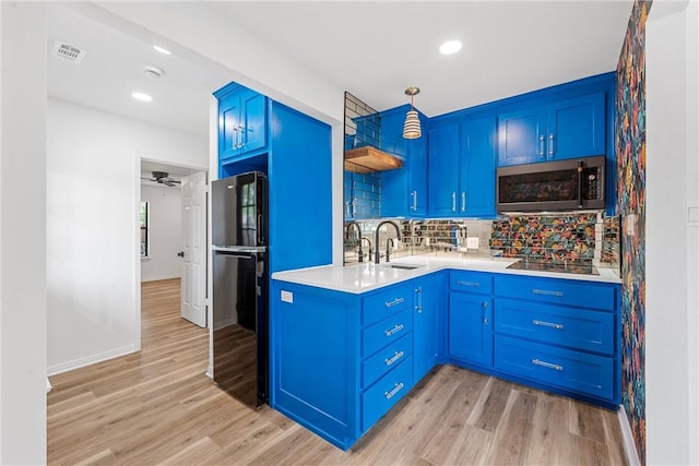 kitchen with decorative backsplash, blue cabinets, sink, black appliances, and light hardwood / wood-style flooring