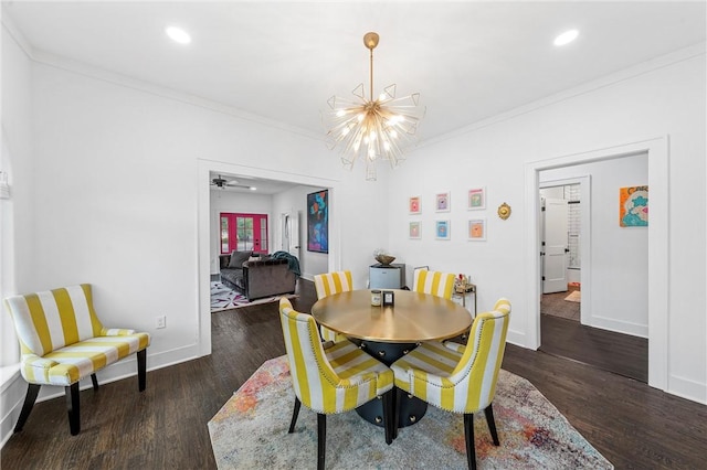 dining area with ceiling fan with notable chandelier, dark hardwood / wood-style floors, and ornamental molding