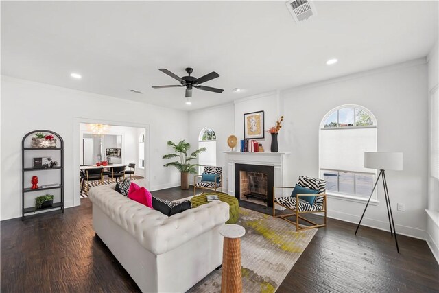 living room with ceiling fan, dark hardwood / wood-style flooring, and ornamental molding