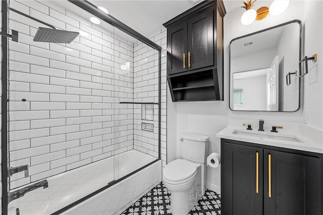 full bathroom with vanity, bath / shower combo with glass door, and toilet