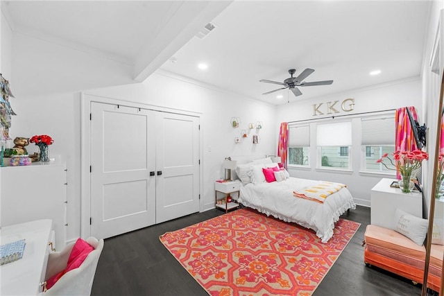 bedroom with beamed ceiling, dark hardwood / wood-style flooring, a closet, and ceiling fan