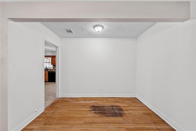 unfurnished room featuring a textured ceiling and hardwood / wood-style flooring