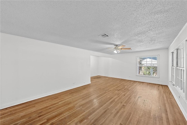 unfurnished room featuring ceiling fan, light wood-type flooring, and a textured ceiling