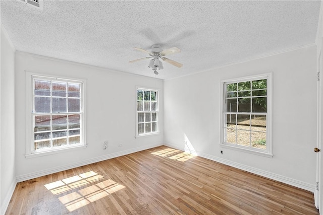 empty room with a textured ceiling, ceiling fan, light hardwood / wood-style flooring, and plenty of natural light