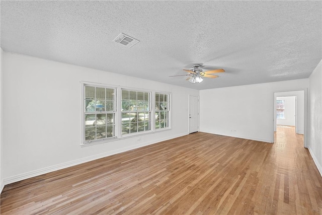 unfurnished living room with a textured ceiling, light wood-type flooring, and ceiling fan