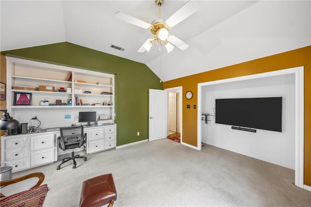 carpeted office with built in shelves, vaulted ceiling, and ceiling fan