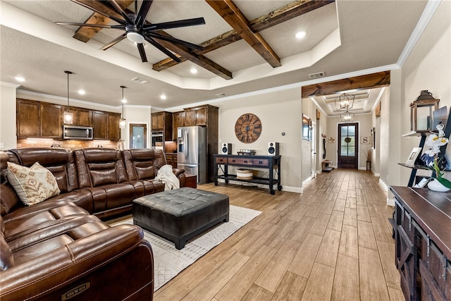 living room featuring a raised ceiling, ceiling fan, coffered ceiling, and ornamental molding