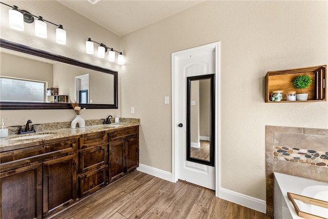 bathroom featuring a washtub, hardwood / wood-style floors, and vanity