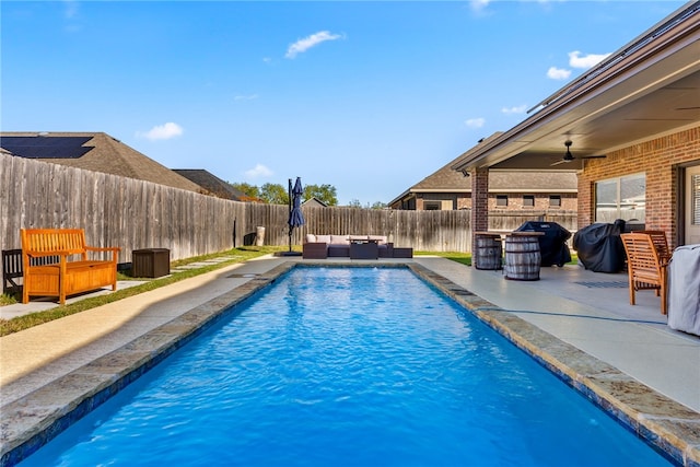 view of pool with a patio area, an outdoor living space, ceiling fan, and area for grilling