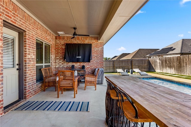 view of patio / terrace with outdoor lounge area, a bar, a fenced in pool, and ceiling fan