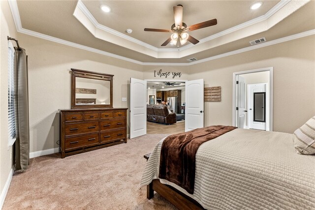 bedroom featuring a tray ceiling, ceiling fan, crown molding, and light carpet