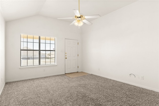 spare room featuring ceiling fan, baseboards, vaulted ceiling, and light colored carpet