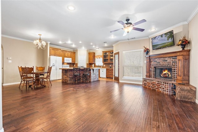 living area with ornamental molding, dark wood-style flooring, and a fireplace