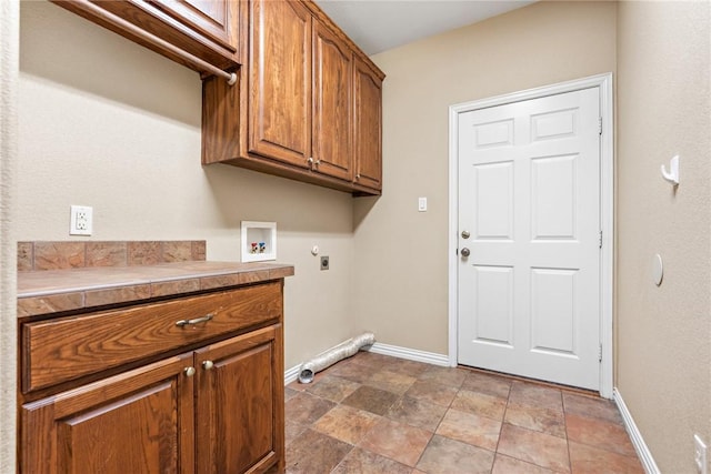 laundry room with hookup for a washing machine, cabinet space, electric dryer hookup, and baseboards