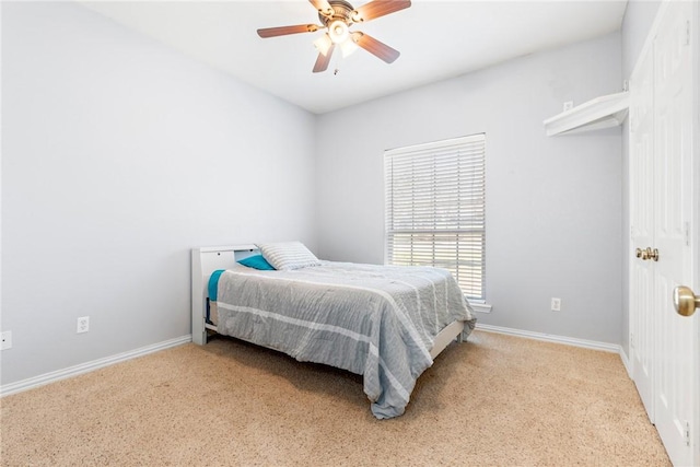 bedroom with a ceiling fan, light colored carpet, and baseboards