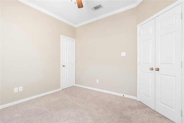 unfurnished bedroom with light carpet, baseboards, visible vents, and crown molding