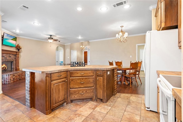 kitchen with brown cabinets, a kitchen island, light countertops, and white electric range