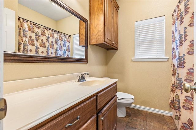 full bath featuring vanity, toilet, and baseboards