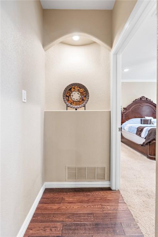 corridor featuring dark wood finished floors, visible vents, and baseboards