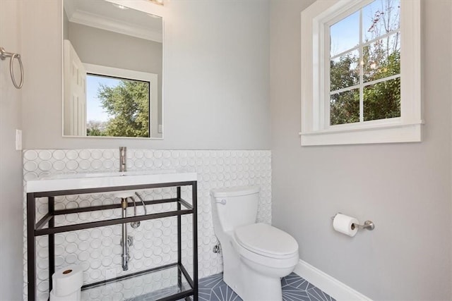 bathroom with sink, toilet, ornamental molding, and tile patterned flooring