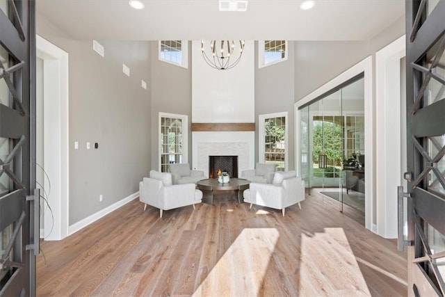 living room with light hardwood / wood-style floors and a notable chandelier