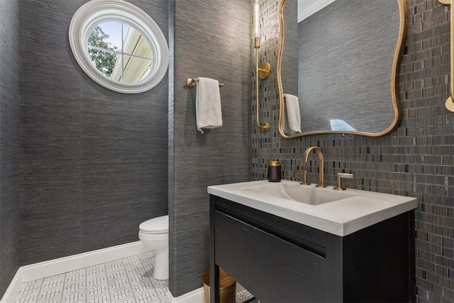 bathroom with toilet, vanity, tasteful backsplash, and tile patterned flooring