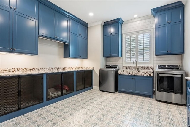 kitchen featuring blue cabinetry, washer / dryer, ornamental molding, and stove