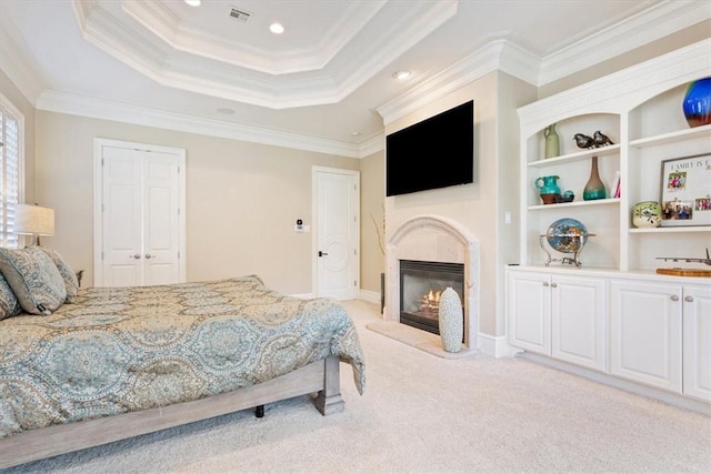 carpeted bedroom featuring a raised ceiling, a closet, and ornamental molding