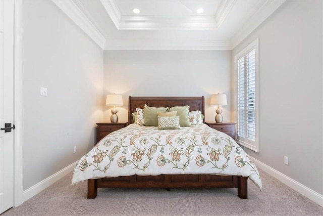 carpeted bedroom with a tray ceiling and ornamental molding