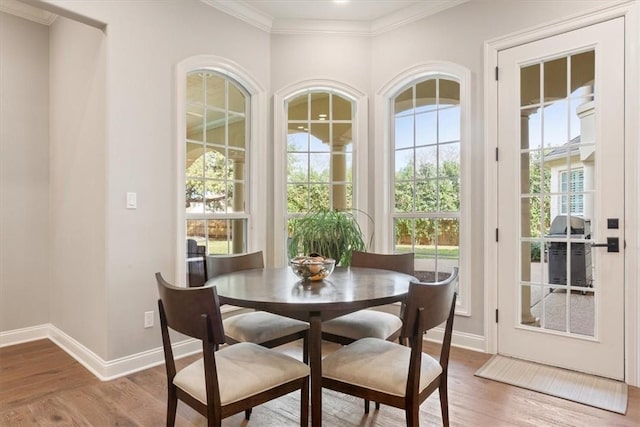 dining space with wood-type flooring and crown molding