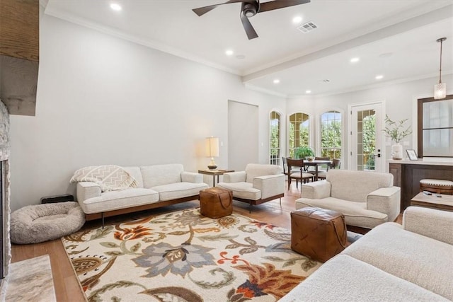 living room featuring ceiling fan, crown molding, and light hardwood / wood-style flooring